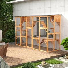 an outdoor room with wooden furniture and plants on the decking area in front of it