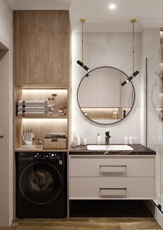 a washer and dryer in a bathroom with wooden floors, white walls and cabinets