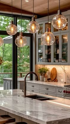 a kitchen with marble counter tops and hanging lights