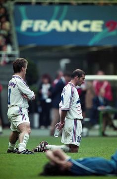 two soccer players are sitting on the grass