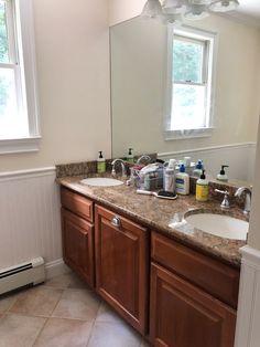 a bathroom with two sinks and a large mirror in it's center area,