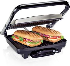 two sandwiches are being grilled on an electric griddle with the lid open to let them cool