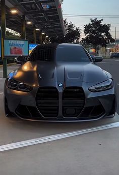 a black sports car parked in front of a gas station with no one around it