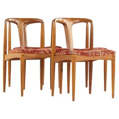 two wooden chairs sitting next to each other on top of a white surface with red fabric