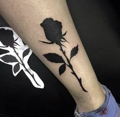 a black rose tattoo on the leg