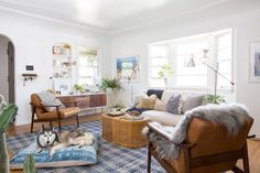 a living room filled with furniture and a dog on a pillow in front of the couch