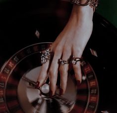 a woman's hand on top of a roule with several rings around it