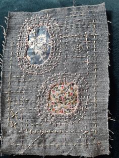 an old piece of cloth with stitchs and holes in the middle, on a blue surface