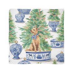 a dog is sitting in front of some blue and white vases with christmas trees on them