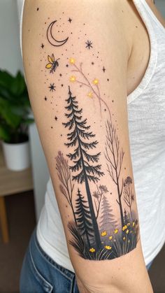 a woman's arm with trees and stars on it