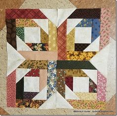 a close up of a patchwork quilt on a table top with many different colors and patterns