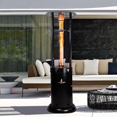 an outdoor heater sitting on top of a patio next to a couch and table