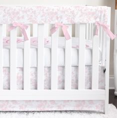 a white crib with pink bows on it