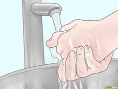 a person washing their hands under a faucet with water running from the faucet