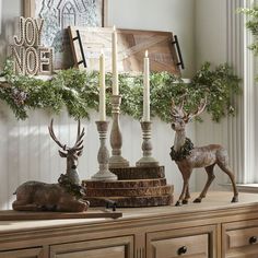 christmas decorations with candles and deer figurines on a dresser in the living room