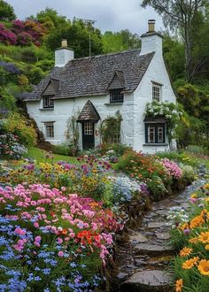 a house with flowers in front of it and a path leading up to the door