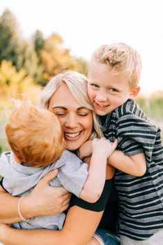 a woman holding a boy and smiling at the camera