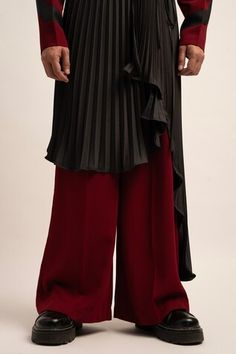 Maroon wide legged trouser. Paired with a pleated asymmetric skirt. - Aza Fashions Evening Bottoms With Pleated Asymmetrical Skirt, Evening Long Skirt With Accordion Pleats, Wide Leg Bottoms With Accordion Pleats For Party, Formal Festive Wide Leg Bottoms, Festive Formal Wide-leg Bottoms, Elegant Long Skirt For Festive Occasions, Elegant Festive Long Skirt, Elegant Ankle-length Festive Bottoms, Elegant Ankle-length Bottoms For Festive Occasions