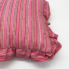 a pink and white striped pillow with ruffled edges