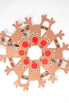 a paper snowflake that has been cut out to look like reindeers with red noses