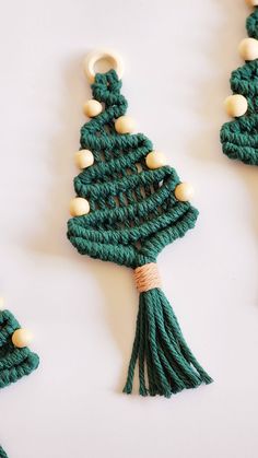 crocheted christmas tree ornaments with white beads and green tassels on them