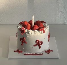 a white cake topped with strawberries and icing