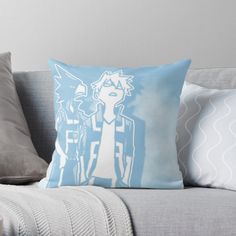 a blue and white throw pillow sitting on top of a couch next to a cup