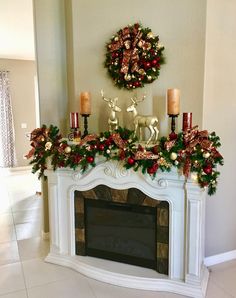 a fireplace decorated for christmas with candles and decorations