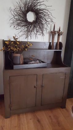 a wooden cabinet with a wreath above it