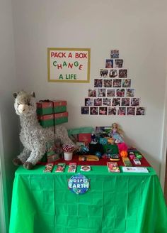 a green table topped with boxes and stuffed animals