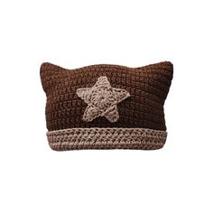 a brown crocheted pillow with a star on the front and bottom, sitting on top of a white surface