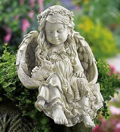 an angel statue sitting on top of a planter