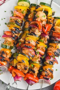 chicken and vegetable kabobs on a white plate