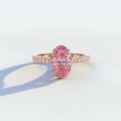 an oval shaped pink diamond ring with diamonds surrounding it