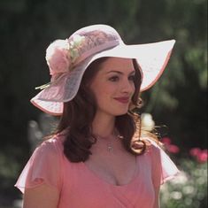 a woman wearing a pink hat with flowers on it