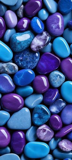 many different colored rocks are arranged in the shape of heart shaped stones, with blue and purple hues on them