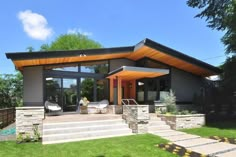 a modern house with large windows and steps leading up to the front door