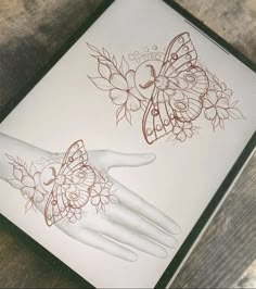 two tattoos on the palm of a person's hand, one with butterfly wings