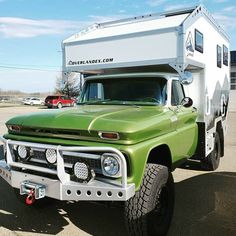 an old green truck with a camper attached to it's front bumpers