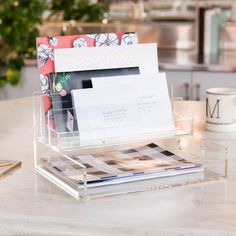 an office desk with a clear plastic holder holding papers and magazines on top of it