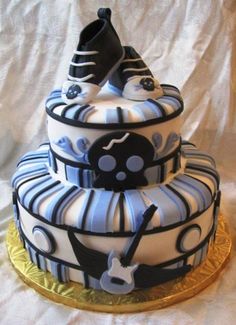 a three tiered cake is decorated with black and white stripes, guitars, and music notes