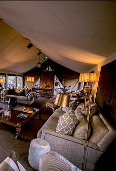 a living room filled with lots of furniture under a large white tent covered in windows