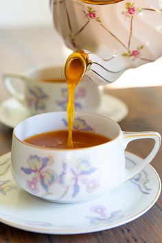 tea being poured into a cup on a saucer