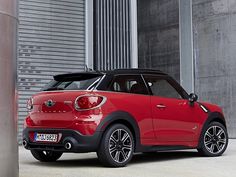 a small red car parked in front of a building