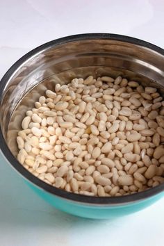 a blue bowl filled with beans on top of a table