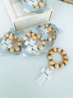 two bracelets with wooden beads are sitting on a table next to a box and cross