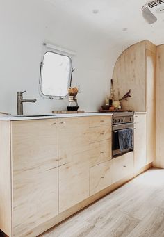 a kitchen with wooden cabinets and an oven on the counter top in front of a mirror