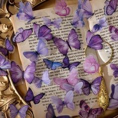 purple butterflies on an old book with gold trimmings and ornate frame around them