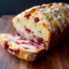 a loaf of cranberry bread sitting on top of a wooden cutting board