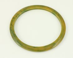 Vintage Marbled Yellow Green Bakelite Stacker Bangle Bracelet. Made in the 1940s, this marbled green and golden yellow bangle bracelet would be great in a stack with other Bakelite bangles. Tests positive as Bakelite with Simichrome test. Good vintage condition with some minor surface wear. ERA: WWII, 1940s METAL/MATERIAL: Bakelite Plastic CONDITION: Good Vintage Condition, with minor surface wear. Previously owned and worn. MEASUREMENTS: Inner circumference of 8 inches and width of 3/16 inch Ar Bakelite Bracelets, Bakelite Bangles, Bracelet Vintage, Metal Material, Golden Yellow, Bangle Bracelet, Vienna, Bangle Bracelets, Vintage Jewelry